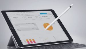 ipad and stylus with business charts and graphs