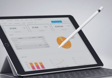 ipad and stylus with business charts and graphs